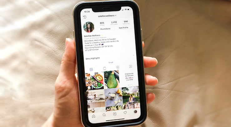 Emily holding her phone with Instagram on the screen